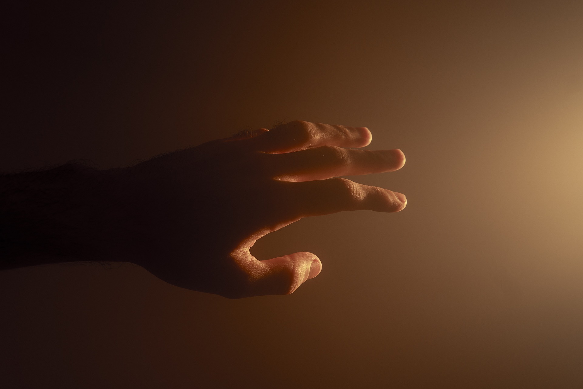 Hand reaching out to a light source