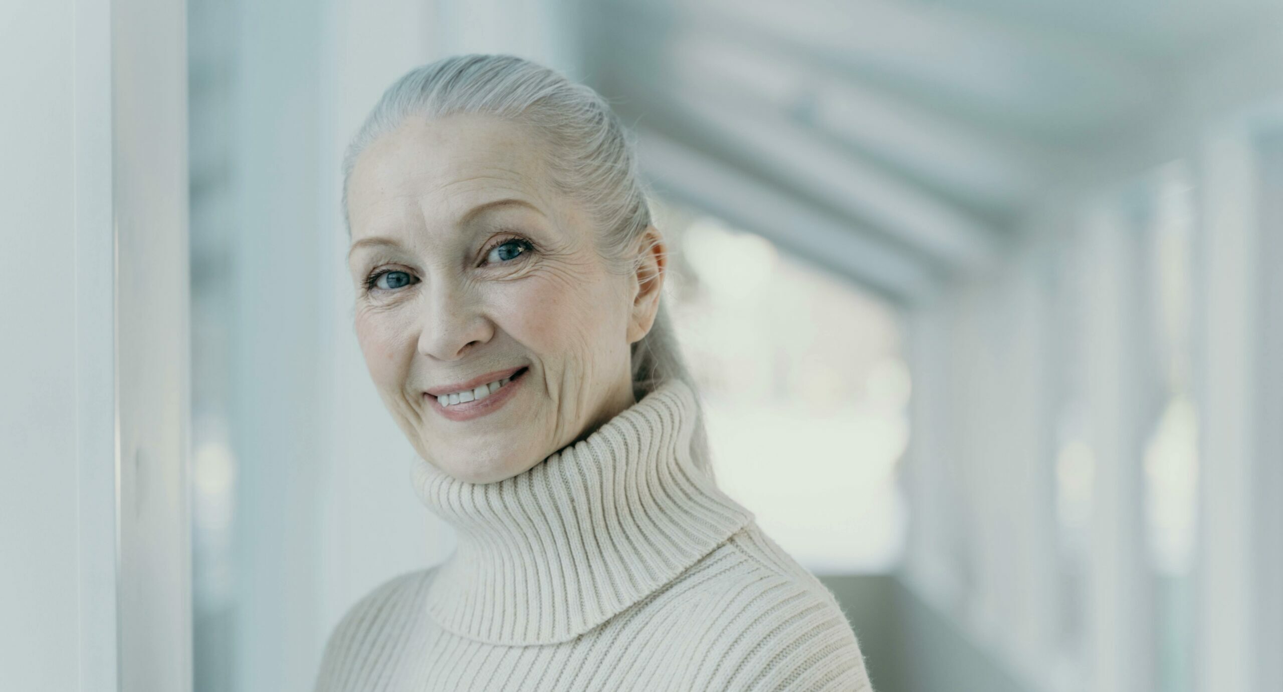 Older woman with grey hair in a white sweater